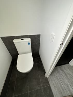 Wall-hung toilet installed on dark feature tile
